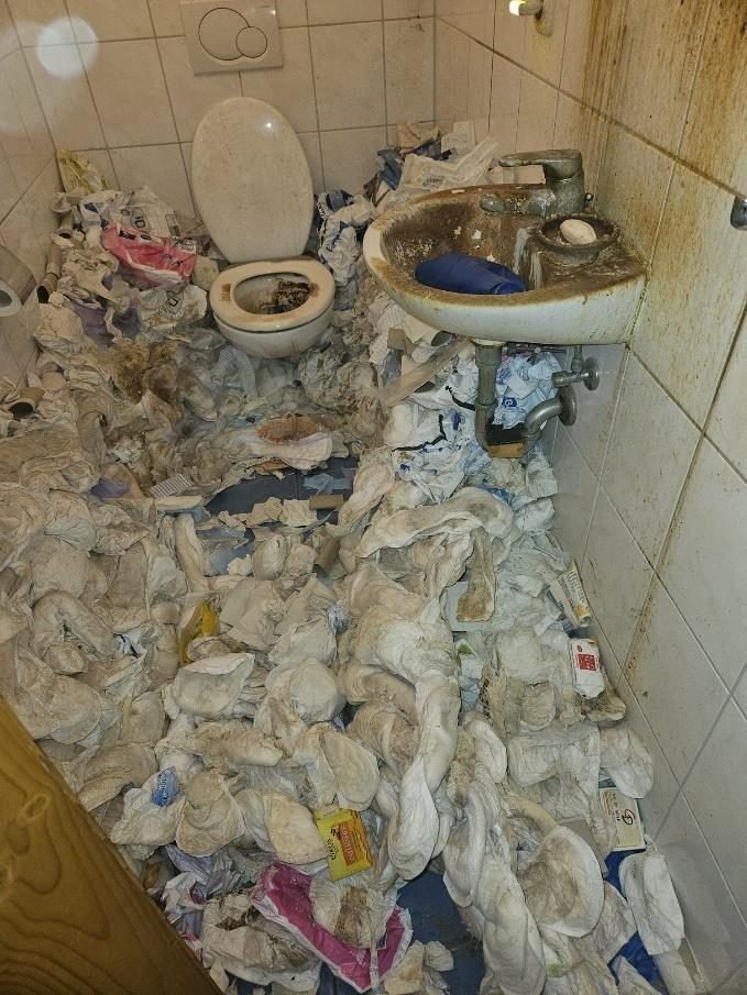 Badezimmer vor der Reinigung, stark verschmutzt und vollgestellt